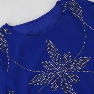 Detail von Gold-Strasssteinen mit Schneeflockenmuster auf marineblauem Chiffonkleid