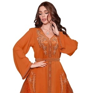 Detail of floral embroidery and sparkling sequins on dark orange kaftan mesh dress