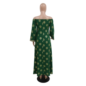 Detail of dark green dress featuring golden leaf foil prints and delicate lace sleeve cuffs