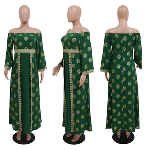 Detail of dark green off-shoulder dress featuring gold floral prints and lace trim