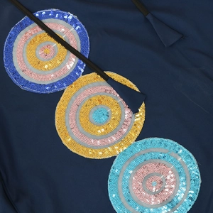 Detail of navy blue dress with colorful sequin embroidery patches and woven drawstrings