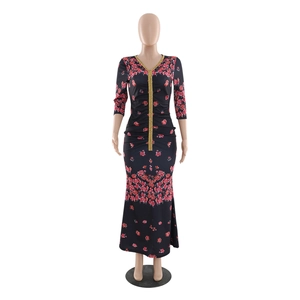 Close-up of V-neckline with gold embroidery and red floral print on a black kaftan dress