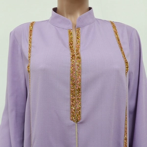 Détail de la jalabiya lavande avec broderies dorées et col mao pour un style traditionnel