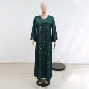 Détails de la robe longue vert foncé avec motifs en perles dorées et col en V profond