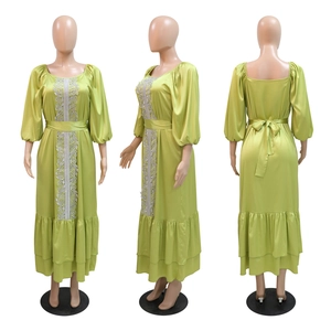 Detail of lime green satin maxi dress with lace trim and elegant puff sleeves