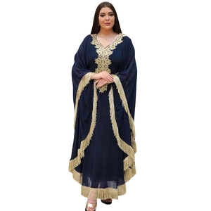 Détails de broderie dorée et de glands sur une robe caftan de couleur bleu marine
