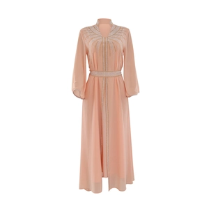 Close-up of sparkling rhinestone patterns on light peach chiffon kaftan dress