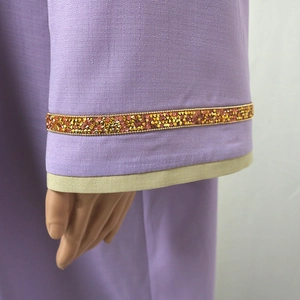 Gros plan détaillé sur la manche de jalabiya violette avec strass dorés luxueux