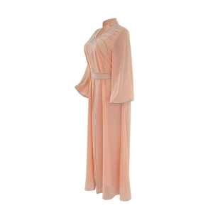 Detail of coral chiffon kaftan dress featuring intricate rhinestone patterns and belt