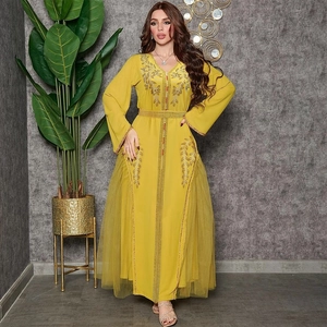 Detail of yellow kaftan dress with golden floral embroidery and sheer mesh panels