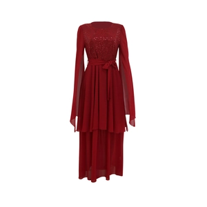 Macro detail of dark red sequined bodice with split-sleeve cape design and waist tie
