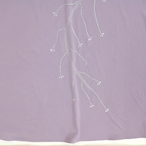 Detail of light purple fabric with sparkling silver rhinestone floral patterns