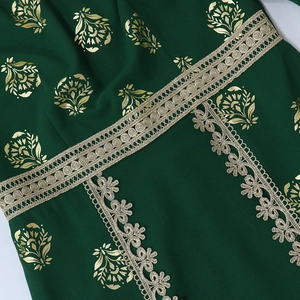 Detailed view of dark green ethnic dress featuring gold floral foil and lace trim