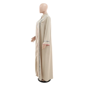 Détail d'une robe jalabiya kaki avec col montant et bordure texturée à motifs