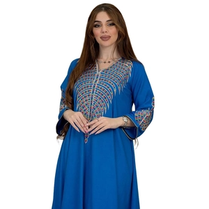 Detailed colorful embroidery on blue kaftan dress with intricate ethnic patterns