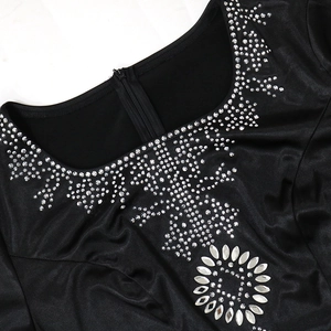 Dettaglio dello scollo rotondo con strass argentati e paillettes su abito nero
