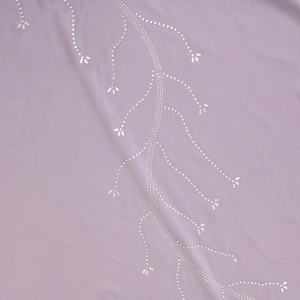Close-up of lavender dress fabric featuring intricate rhinestone flowing branch patterns