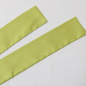 Close-up of lime green satin fabric waist belt with smooth silk texture and fine stitching