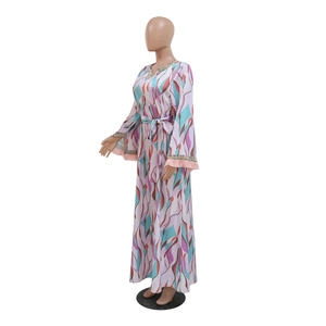 Detail of V-neckline with ethnic braided trim and pink fringe tassels on printed maxi dress