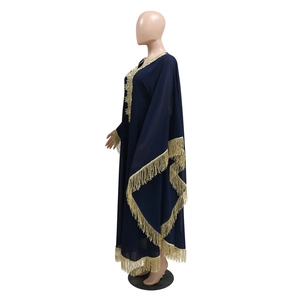 Détail des franges dorées et de la broderie en dentelle sur un caftan bleu marine