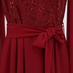 Close-up of red sequined bodice and structured bow belt on a chiffon evening gown