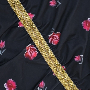 Detailed macro view of pink floral print on black fabric with gold sequin embroidery