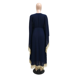Détail de la robe caftan bleu foncé avec d'élégantes franges dorées sur les manches et l'ourlet