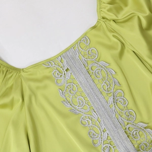Detail of silver lace embroidery on the lime green satin puff sleeve kaftan dress