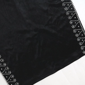 Dettaglio dell'elegante abito da sera nero con strass argentati luccicanti sul tessuto