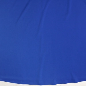 Detailed macro view of royal blue chiffon fabric texture and neat stitched hemline
