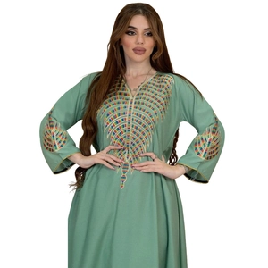 Close-up of vibrant rainbow embroidery on the V-neck and sleeves of this green kaftan dress