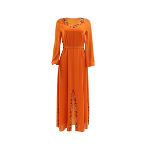 Détail d'une robe en mousseline orange avec des strass brillants sur l'encolure en V