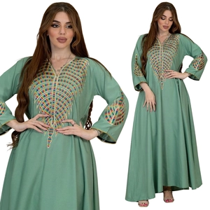 Close-up of colorful radial embroidery on the neckline and sleeves of a light green kaftan