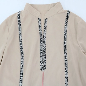 Détail du col en V et col montant avec perles sur la robe musulmane jalabiya beige