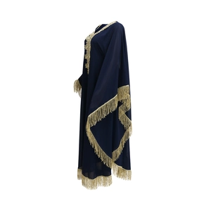 Détail macro du caftan bleu marine avec broderie dorée et finitions à franges fines
