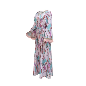 Detail of bohemian kaftan with silver embroidery, sequined trumpet sleeves and pink tassels