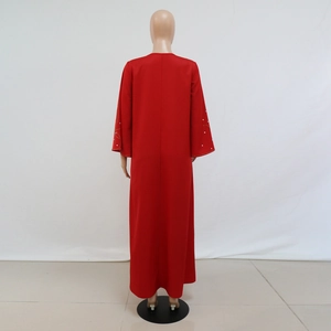Détails du dos du caftan rouge avec broderies dorées et poignets perlés blancs