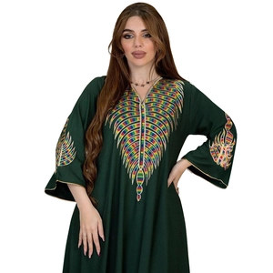 Detail of colorful radial leaf embroidery on the chest of a dark green kaftan dress