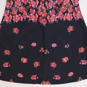 Close-up of black fishtail dress featuring vibrant pink rose floral print and soft fabric