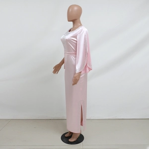 Dettaglio di abito da sera in raso rosa con decorazioni in strass e maniche a cappa
