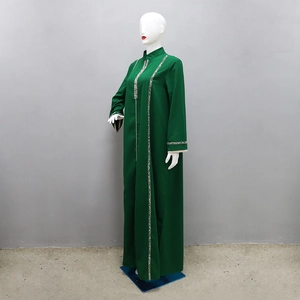Détail d'une abaya jalabiya vert foncé avec broderie géométrique au col et aux poignets