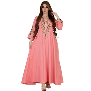 Close-up of pink kaftan dress featuring vibrant colorful radial embroidery on V-neckline