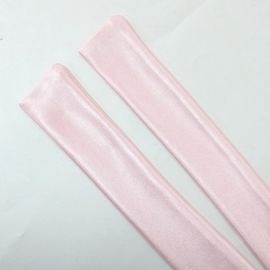 Dettaglio del tessuto rosa chiaro di un abito da sera con strass e texture in seta