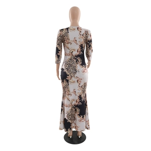 Close-up of slim-fit kaftan dress with leopard and gold baroque patterns on long sleeves