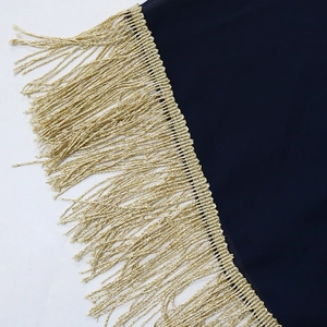 Détail de la robe caftan bleu marine avec garniture de franges à glands dorés