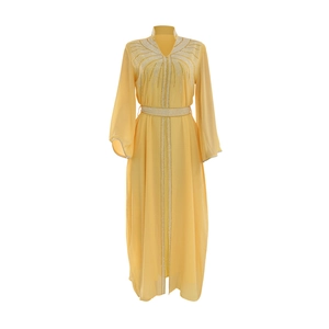 Detail of elegant yellow chiffon kaftan dress with intricate white rhinestone embellishments