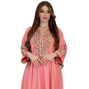 Close-up of colorful geometric embroidery on the V-neckline of a pink kaftan dress