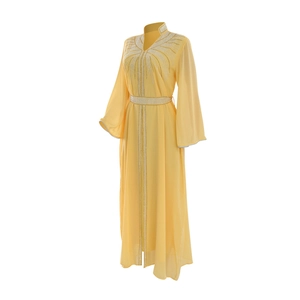 Detail of yellow chiffon kaftan dress featuring intricate silver rhinestone patterns