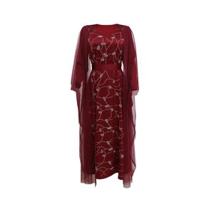 Detail of burgundy two-piece dress featuring polka dot pattern and mesh overlay