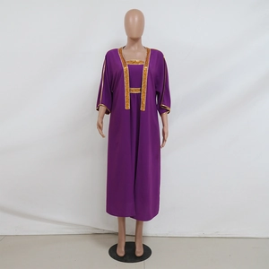 Dettaglio di un vestito maxi kaftan viola con ricami in paillettes dorate sullo scollo